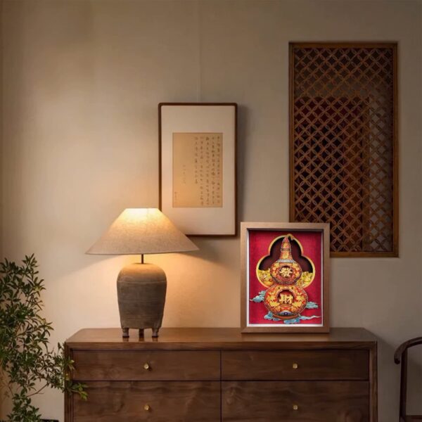 Chinese Paper Cutting Artwork of a 3D fortune gourd displayed in an entryway alongside a lamp