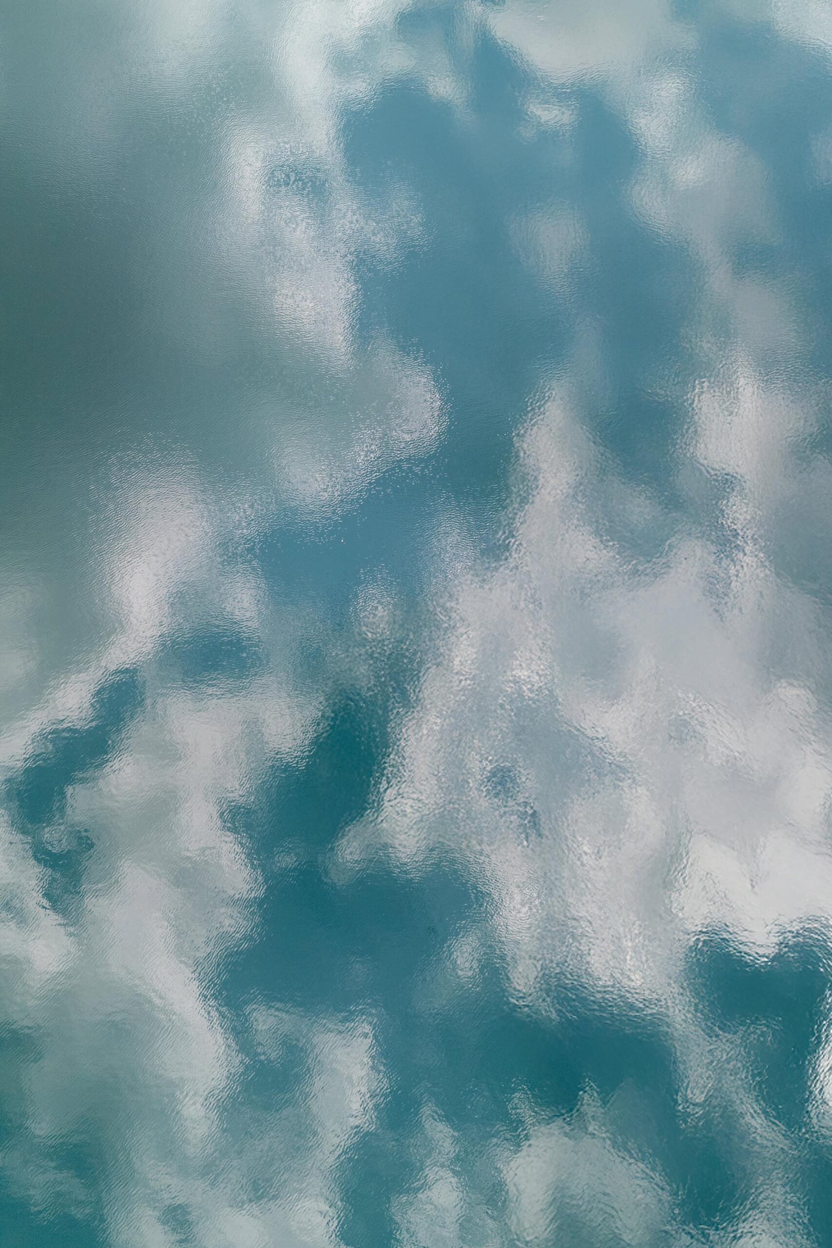 Brilliant blue sky and fluffy white clouds reflecting in the tranquil waters of Guangmingsi Reservoir at Longwu Tea Village