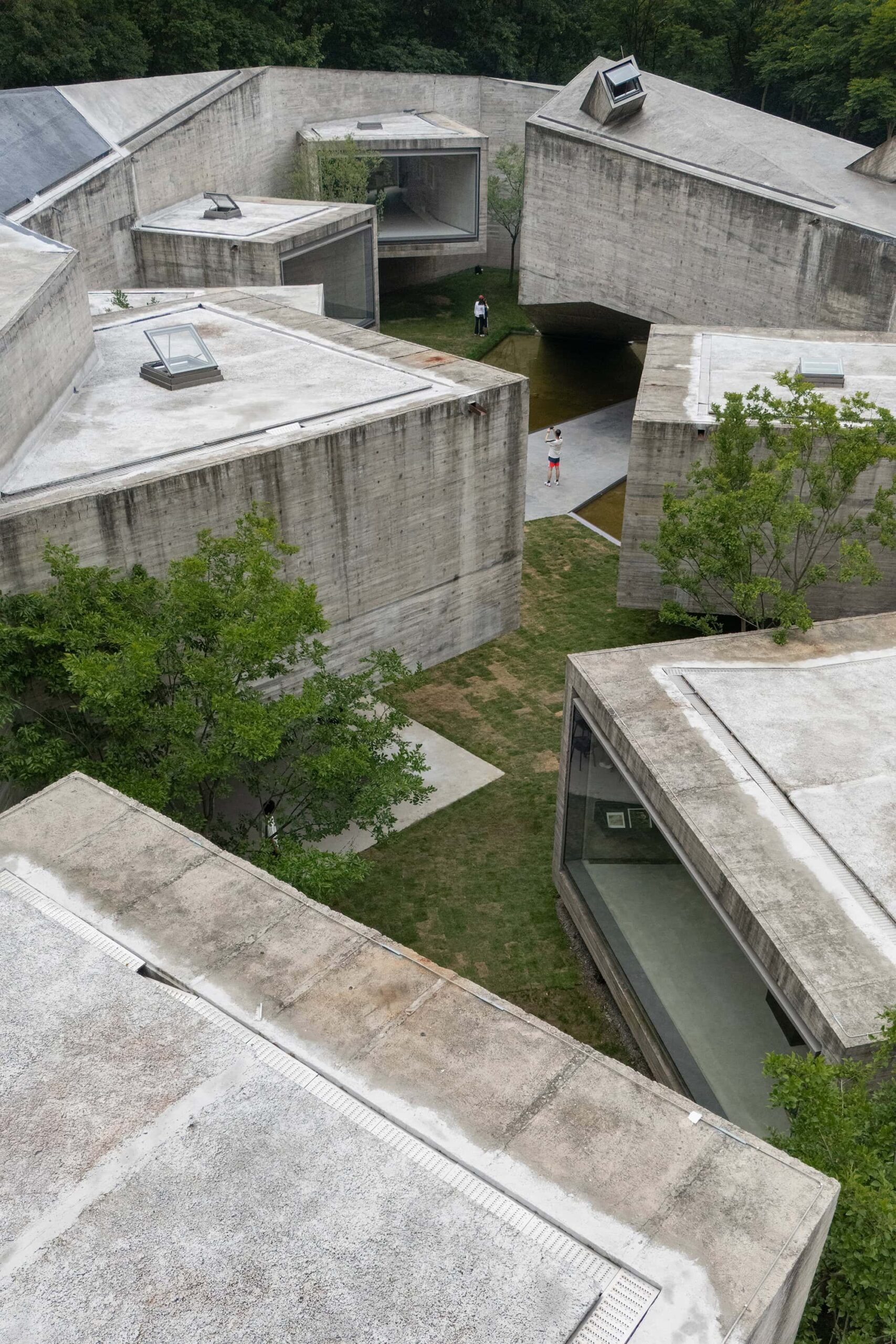 Interlocking volumes of the Xiao Feng Art Museum viewed from a high angle, highlighting its concrete textures and framed windows