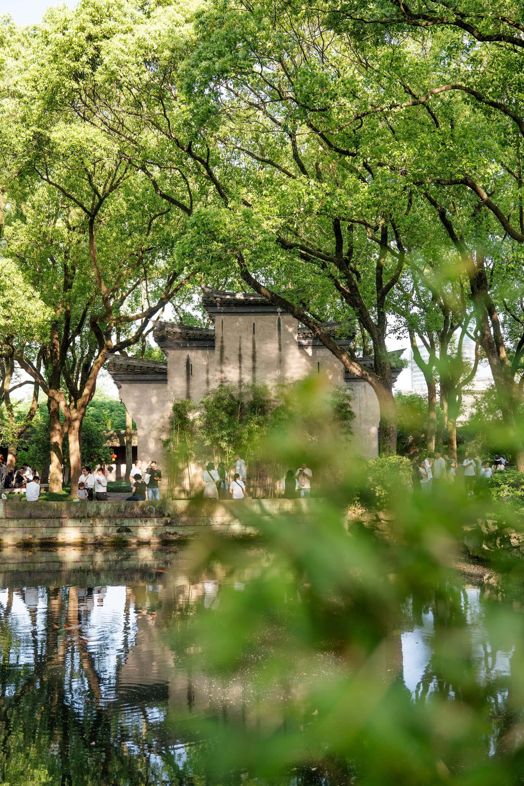 Wide view of the horse-head walls (fireproof walls) in Tianyi Ge East Garden, with dappled tree shadows creating patterns across the scene