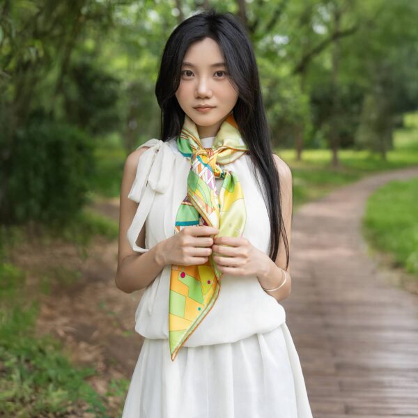 Model demonstrating versatile styling of Wensli silk scarf with casual white outfit in natural outdoor setting