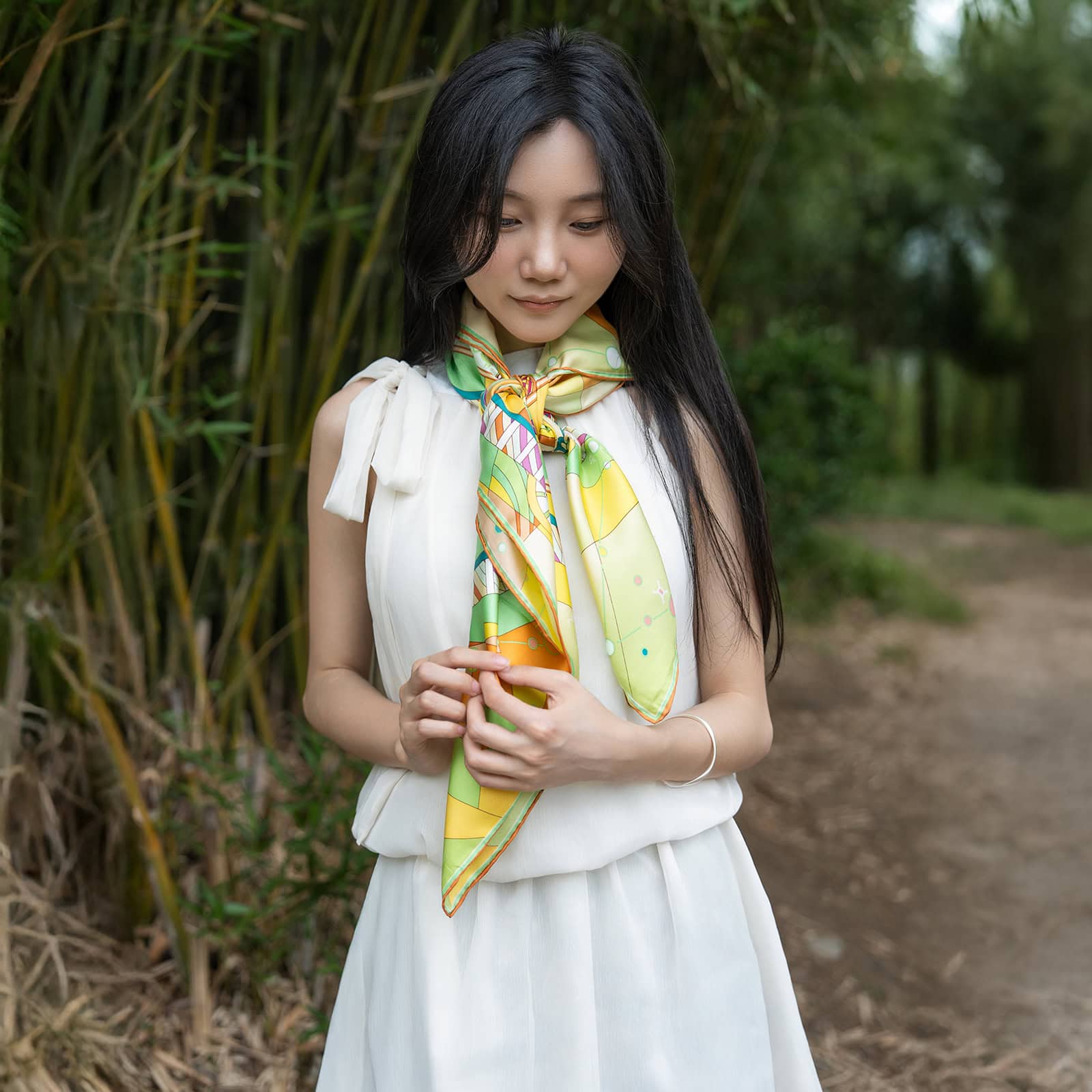 Natural outdoor setting showcasing Wensli silk scarf styling with bamboo background