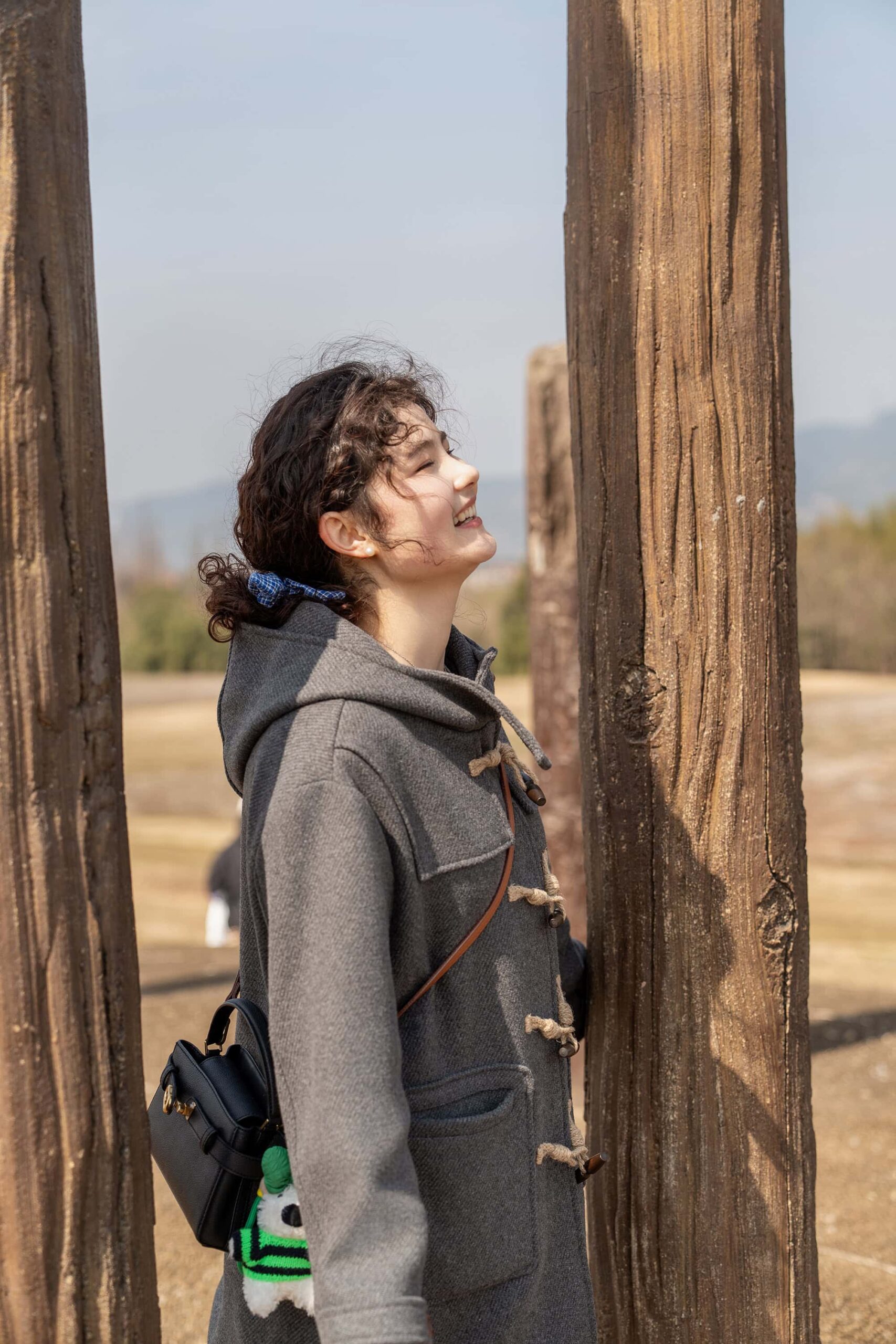 Visitor appreciating the tranquil scenery at Liangzhu City China, surrounded by historic timber structures at Mojiaoshan Palace.