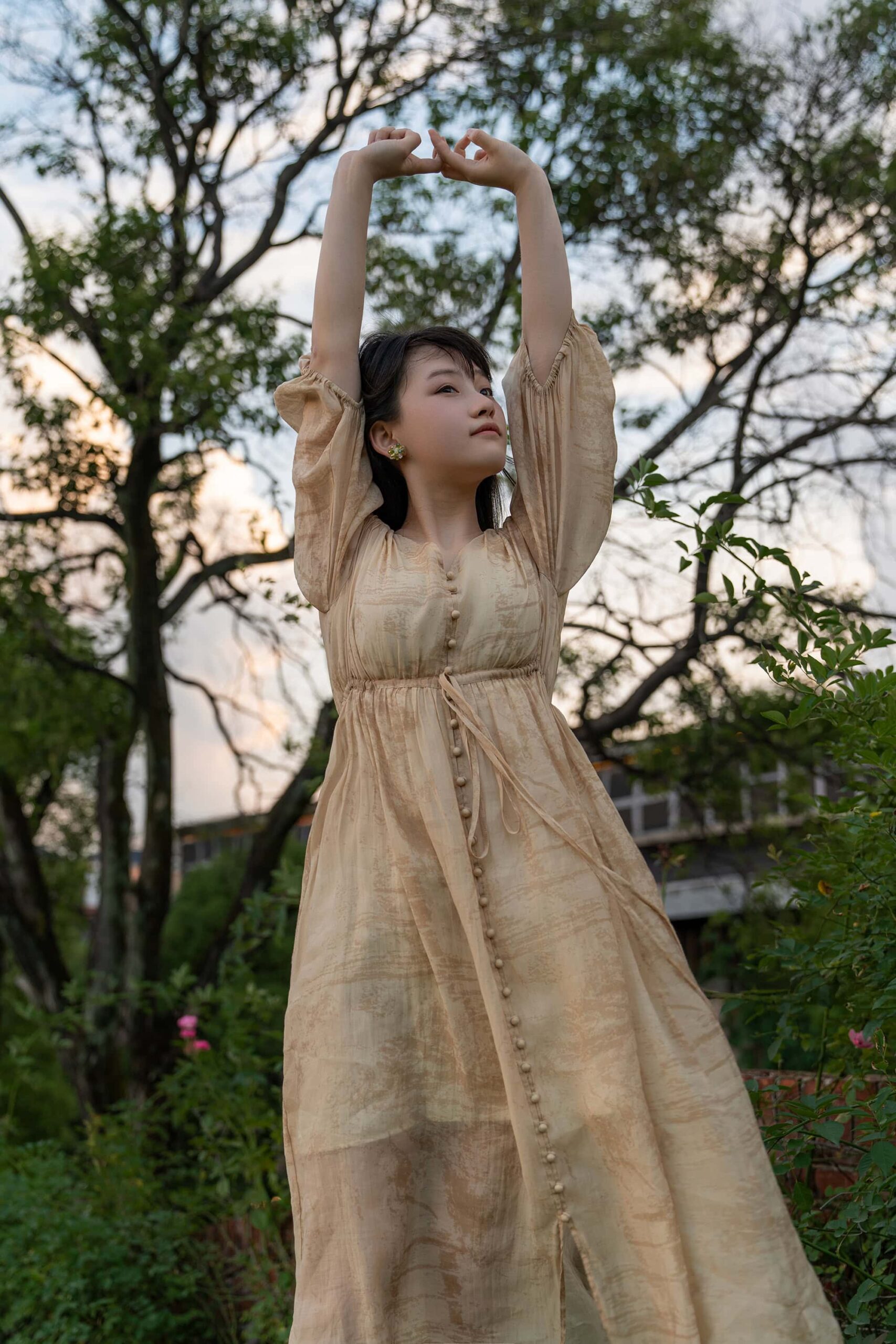 Woman in beige dress stretching gracefully on a slope at Taoxichuan ceramic art avenue
