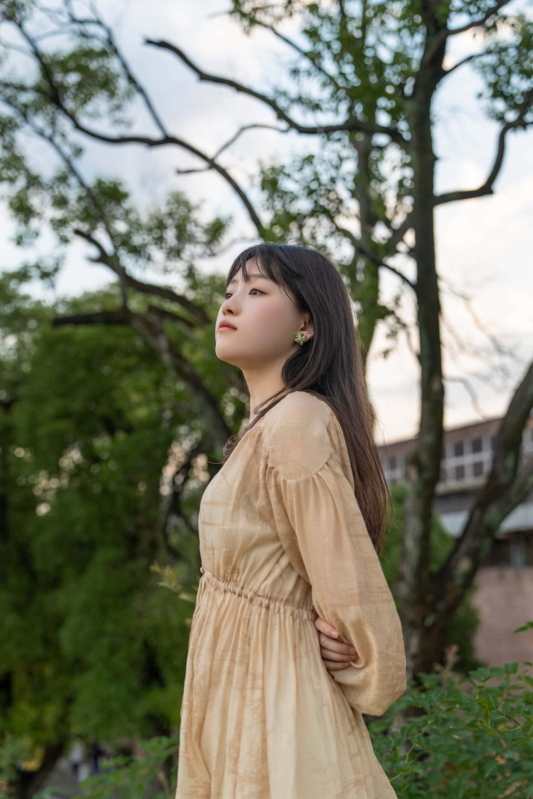 Woman in quiet reflection gazing toward the skyline on a hillside at Taoxichuan ceramic art avenue
