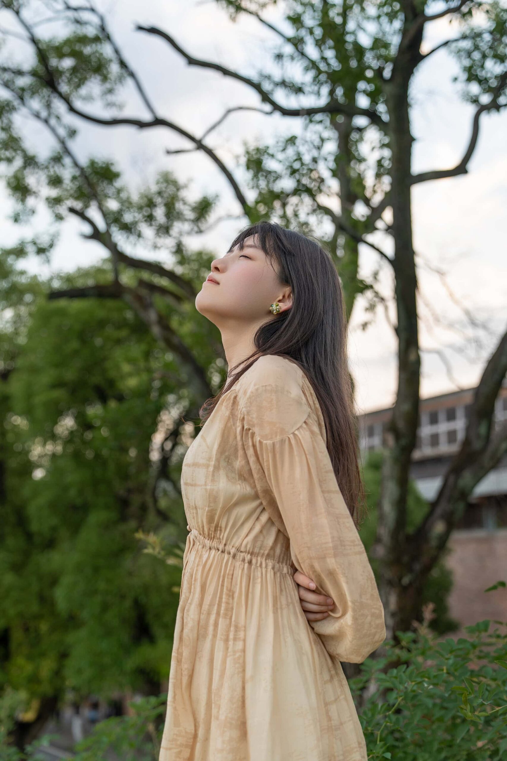 Woman standing peacefully with hands behind her back on a slope at ceramic art avenue Taoxichuan, enjoying the serene atmosphere