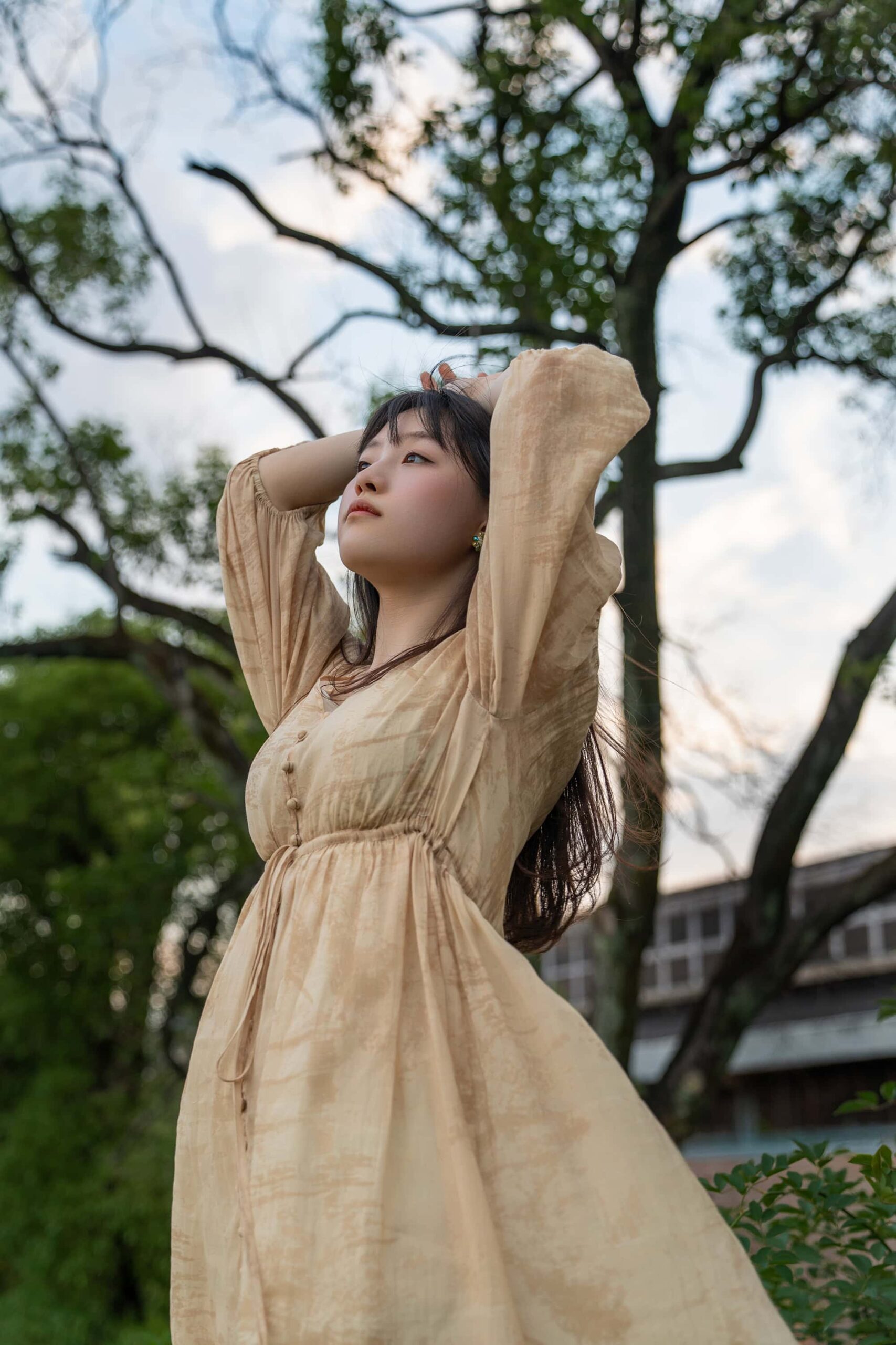 Young woman looking up with hands behind her head on a slope at Taoxichuan ceramic art avenue