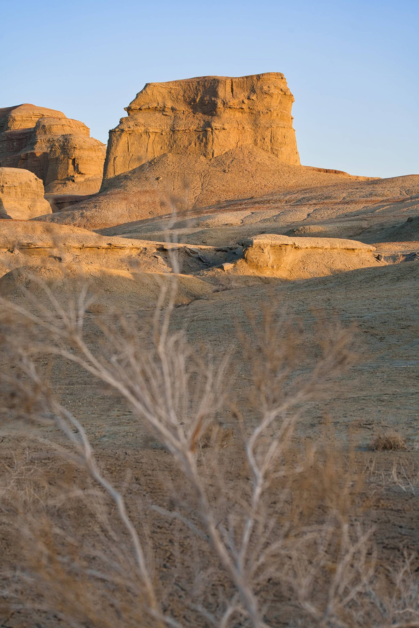 Golden sandstone cliffs in the remote Karamay Ghost City, illustrating the dramatic scenery of ghost city Xinjiang in the fading light.