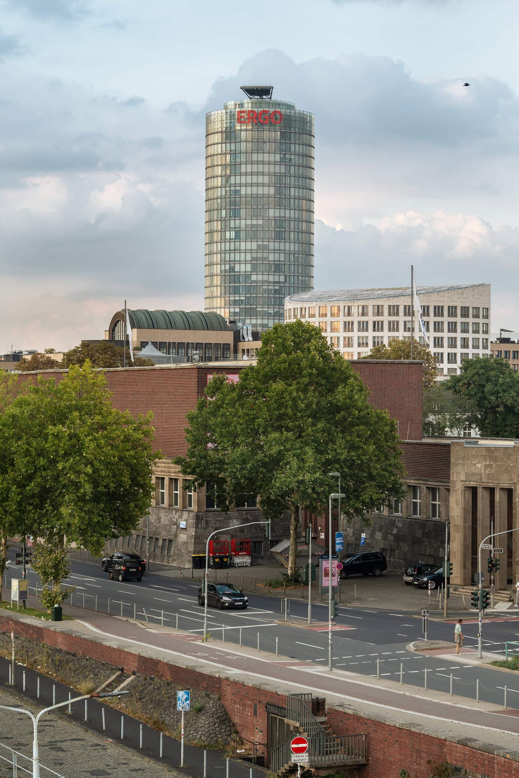 A panoramic view of Düsseldorf’s cityscape near the Rheinuferpromenade, showing the Rhine embankment and modern buildings glowing in the warm evening light