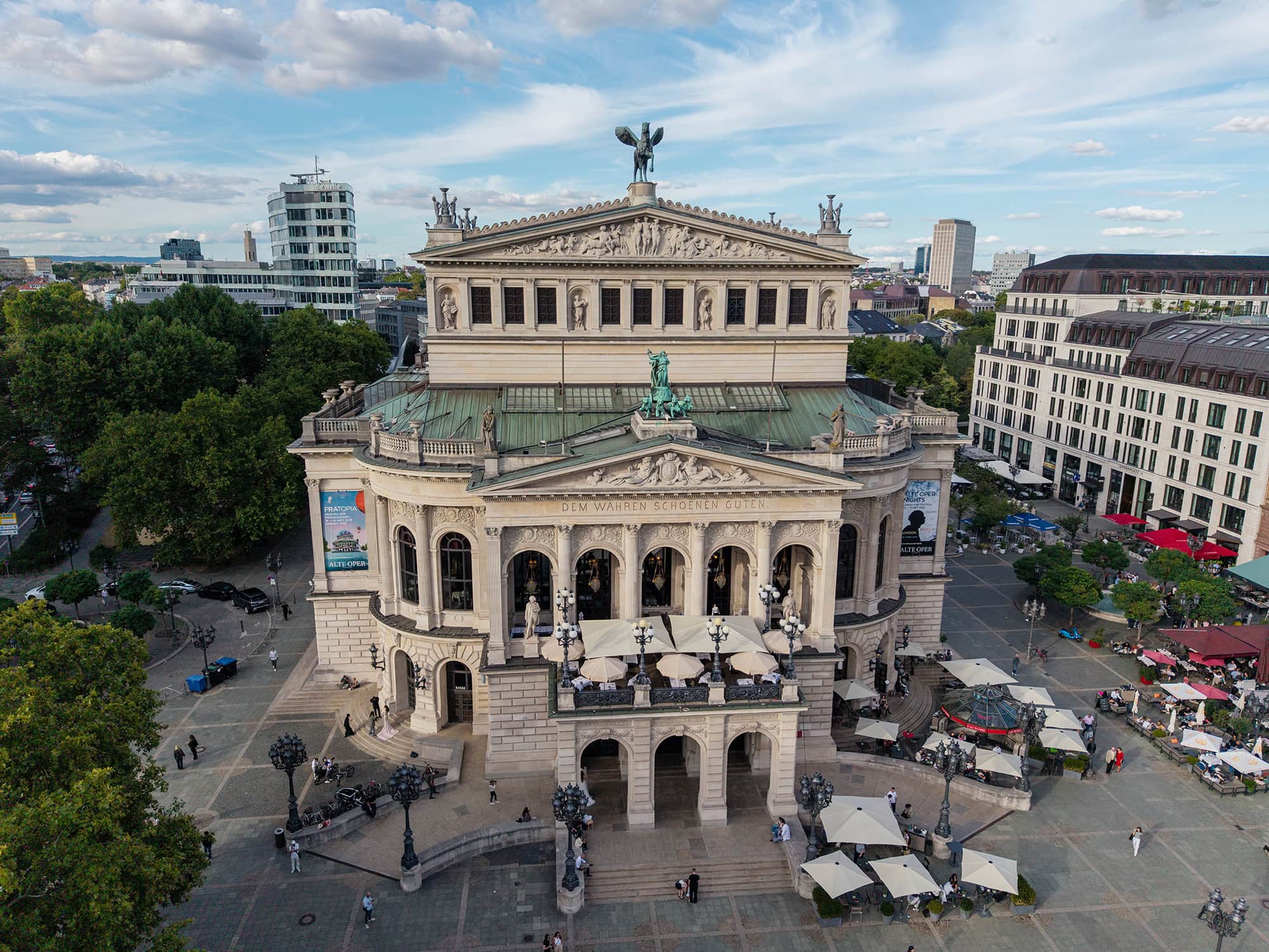 Alte Oper Frankfurt front view with surrounding Opernplatz and cityscape under a blue sky