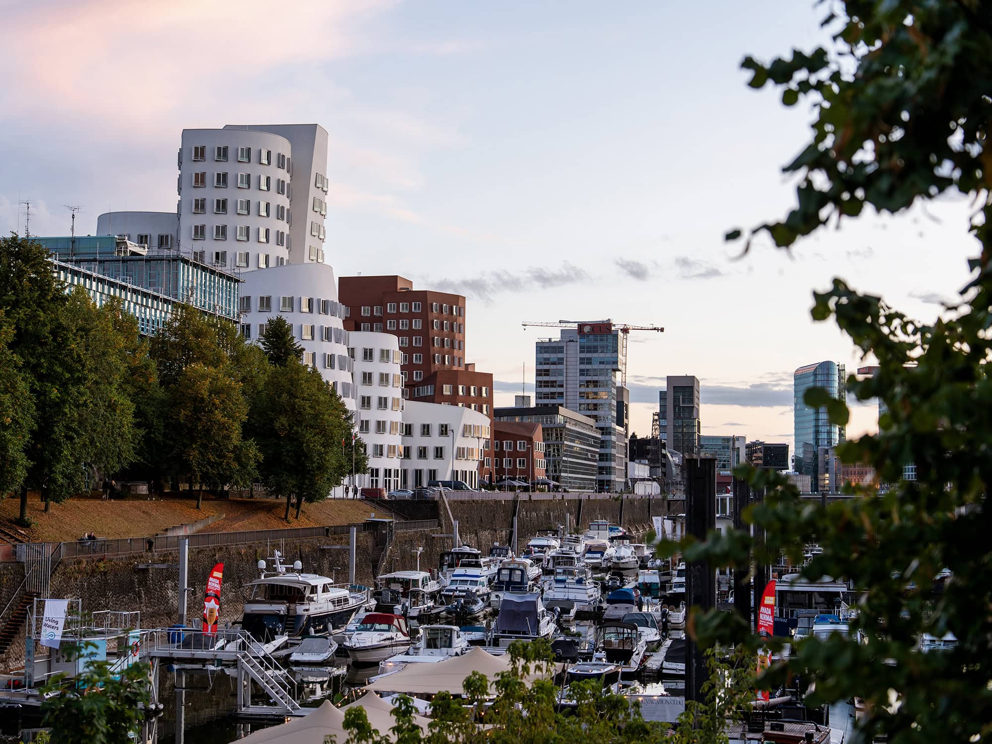 Boats moored along Düsseldorf’s Media Harbor with Frank Gehry’s Neuer Zollhof buildings in the background