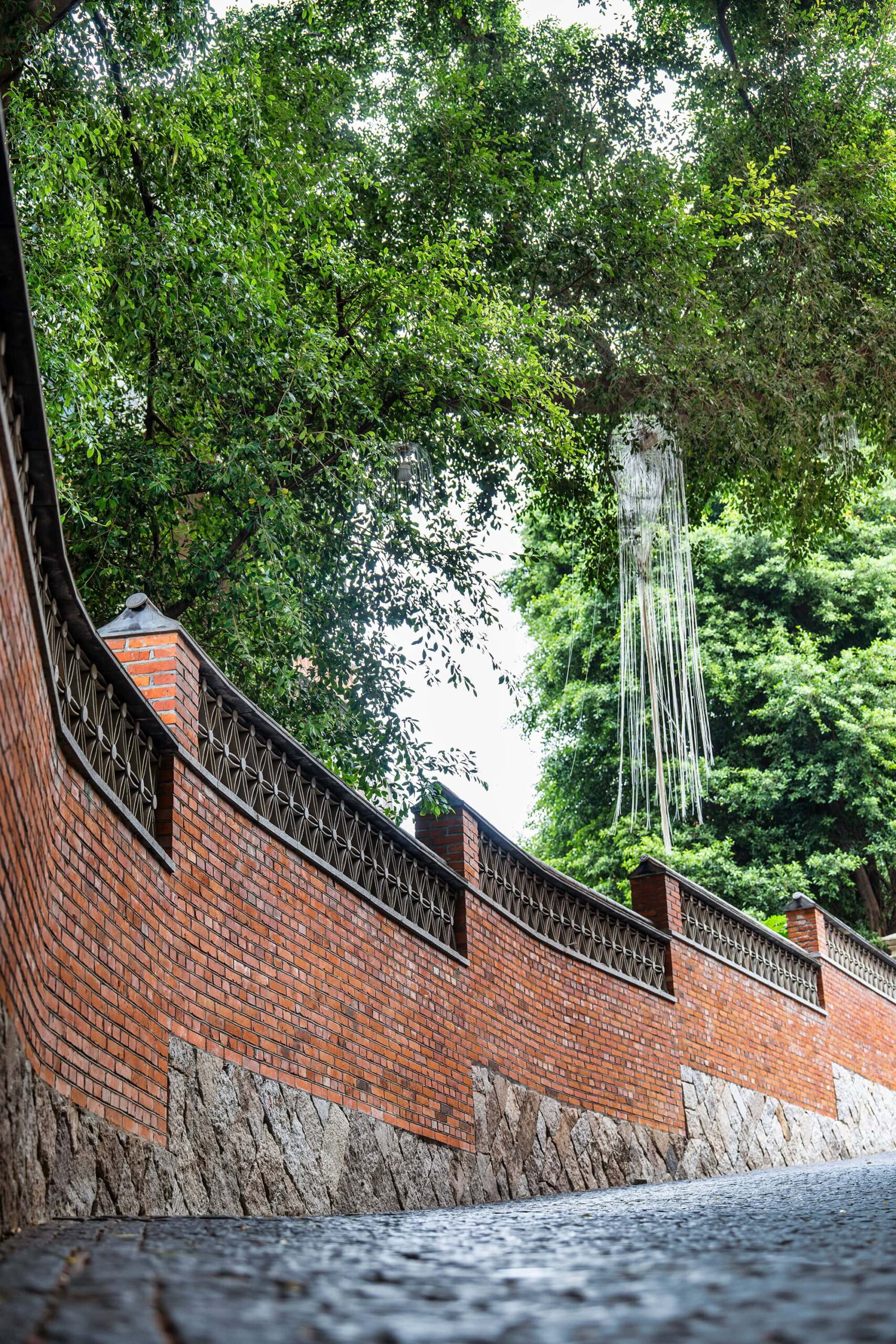 Curved red-brick wall and hanging decorations along the historic path on Yantai Hill, one of the most atmospheric Fuzhou attractions