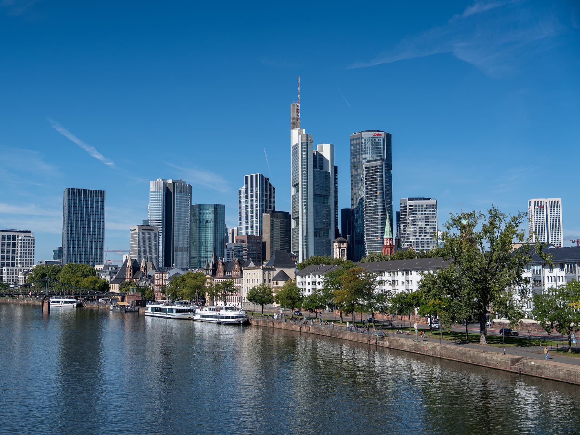 Frankfurt skyline across the Main River, where the modern high‑rises of the financial district meet the historic waterfront near the Museumsufer