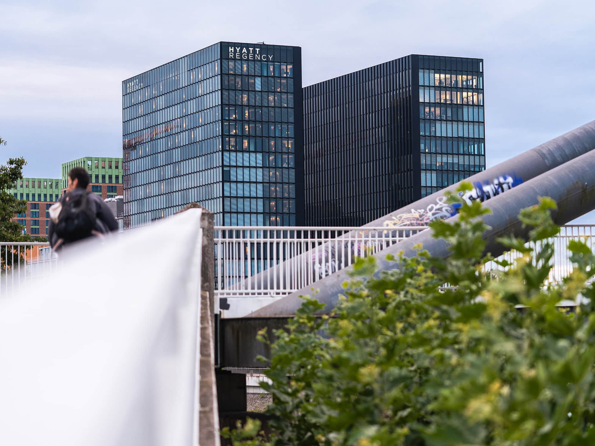 Glass and steel shimmer around the Hyatt Regency Düsseldorf, where contemporary lines meet the calm waters of the Rhine Harbor