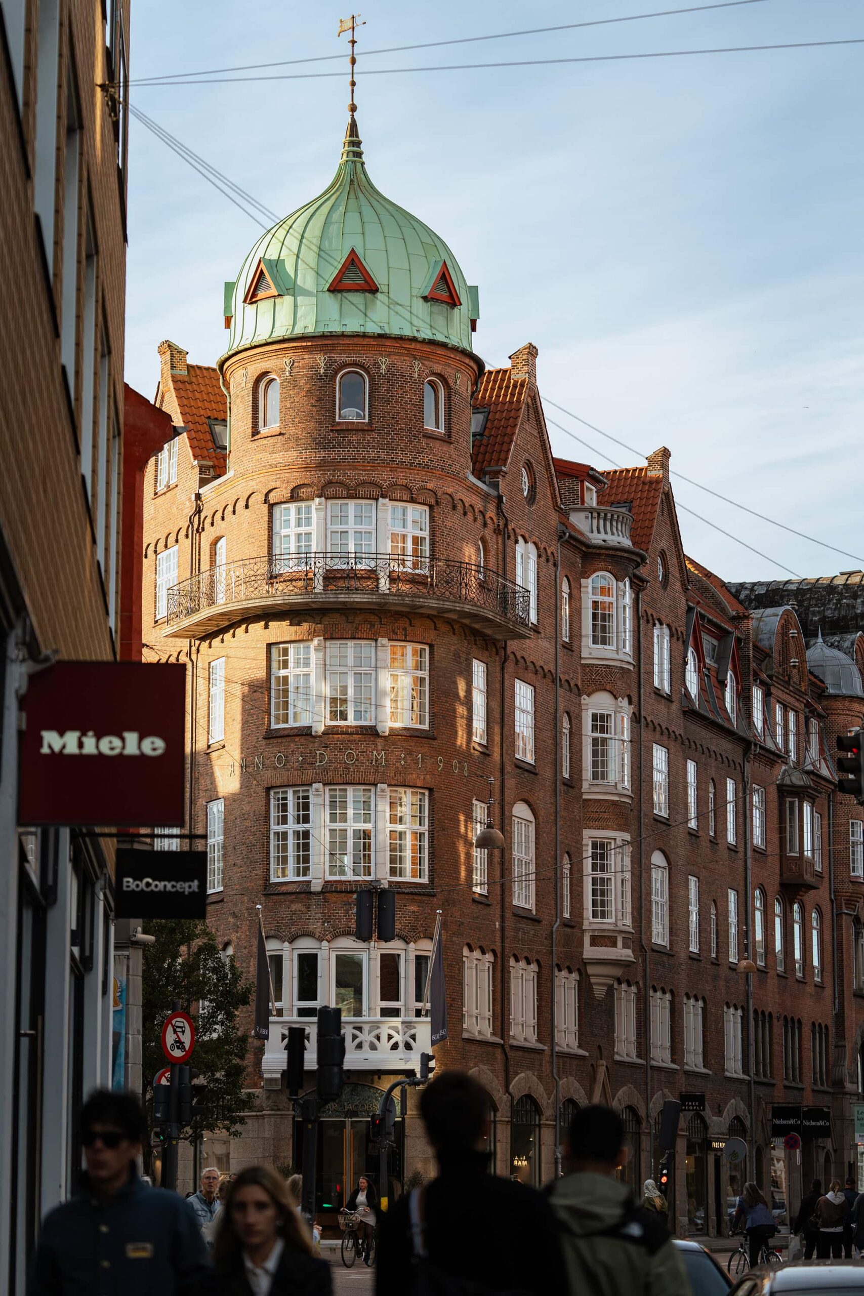 Historic red‑brick architecture with a green copper dome in central Copenhagen