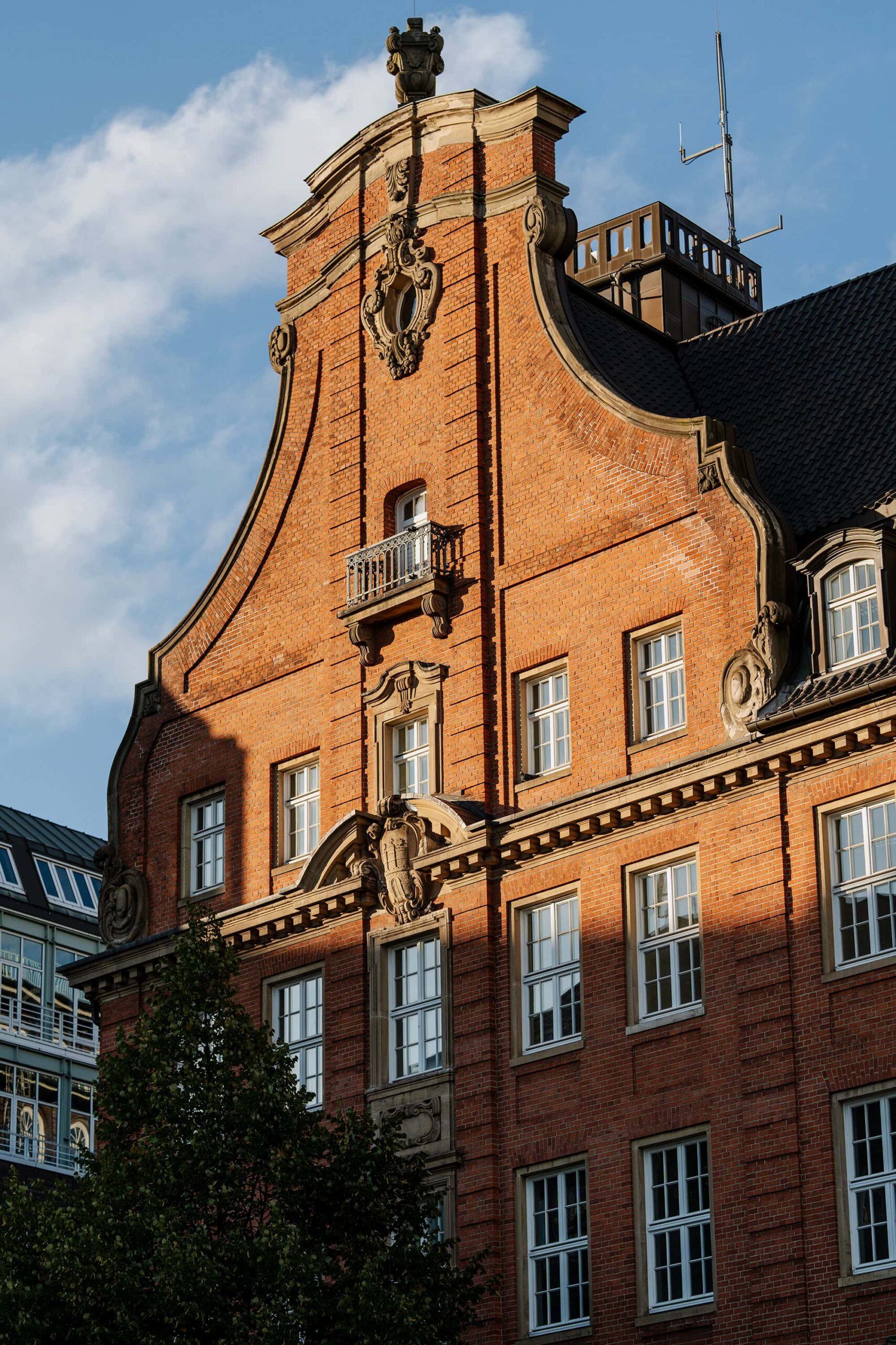 Red‑brick building in Hamburg, showing classic architectural details lit by afternoon light