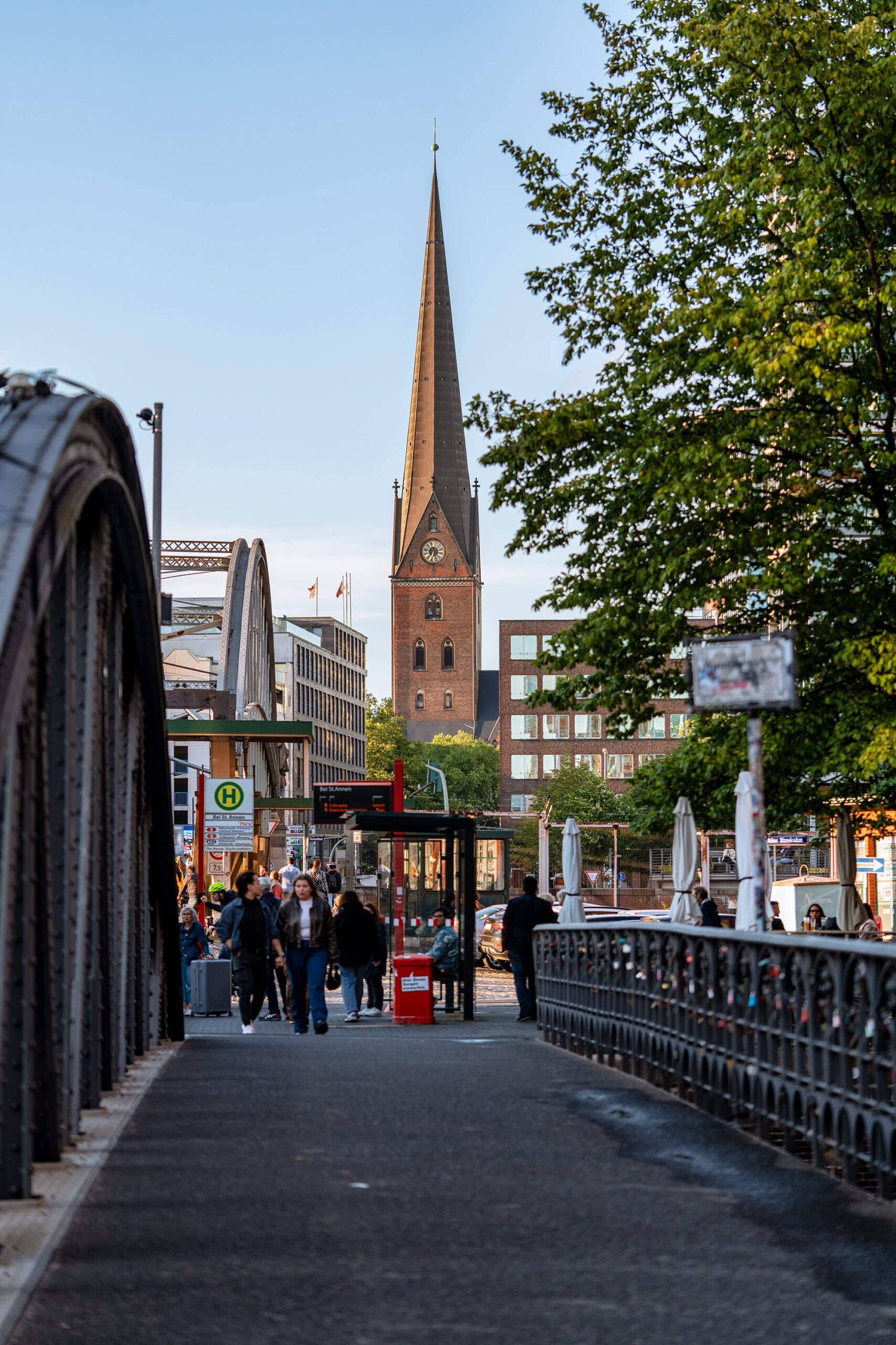 St. Catherine’s Church in Hamburg, Germany, viewed across a bridge amid evening light and passing pedestrians, one of the city’s principal churches