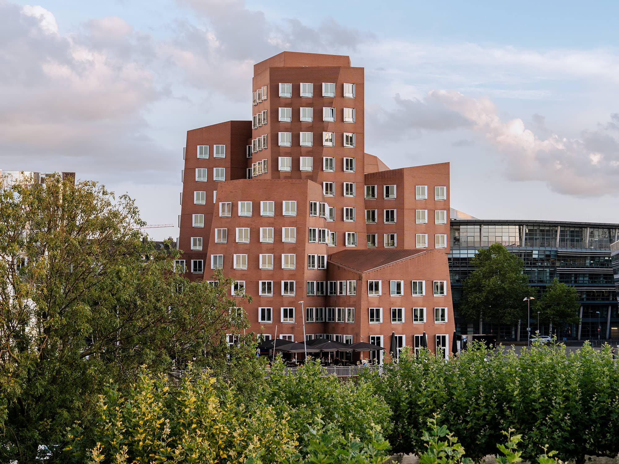 The red‑brick building of Frank Gehry’s Neuer Zollhof in Media Harbor Düsseldorf, seen under soft evening light