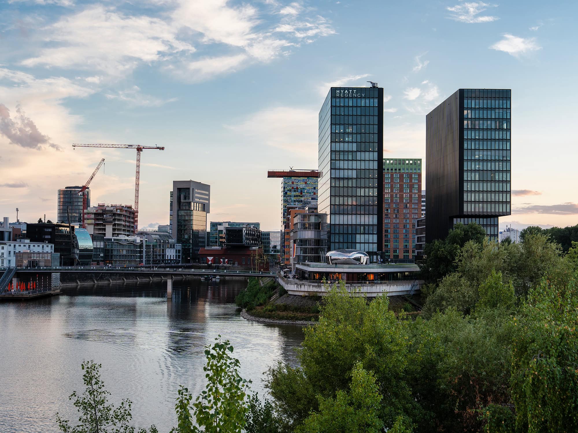 Twin glass towers reflecting the Rhine and sunset sky at Media Harbor Düsseldorf