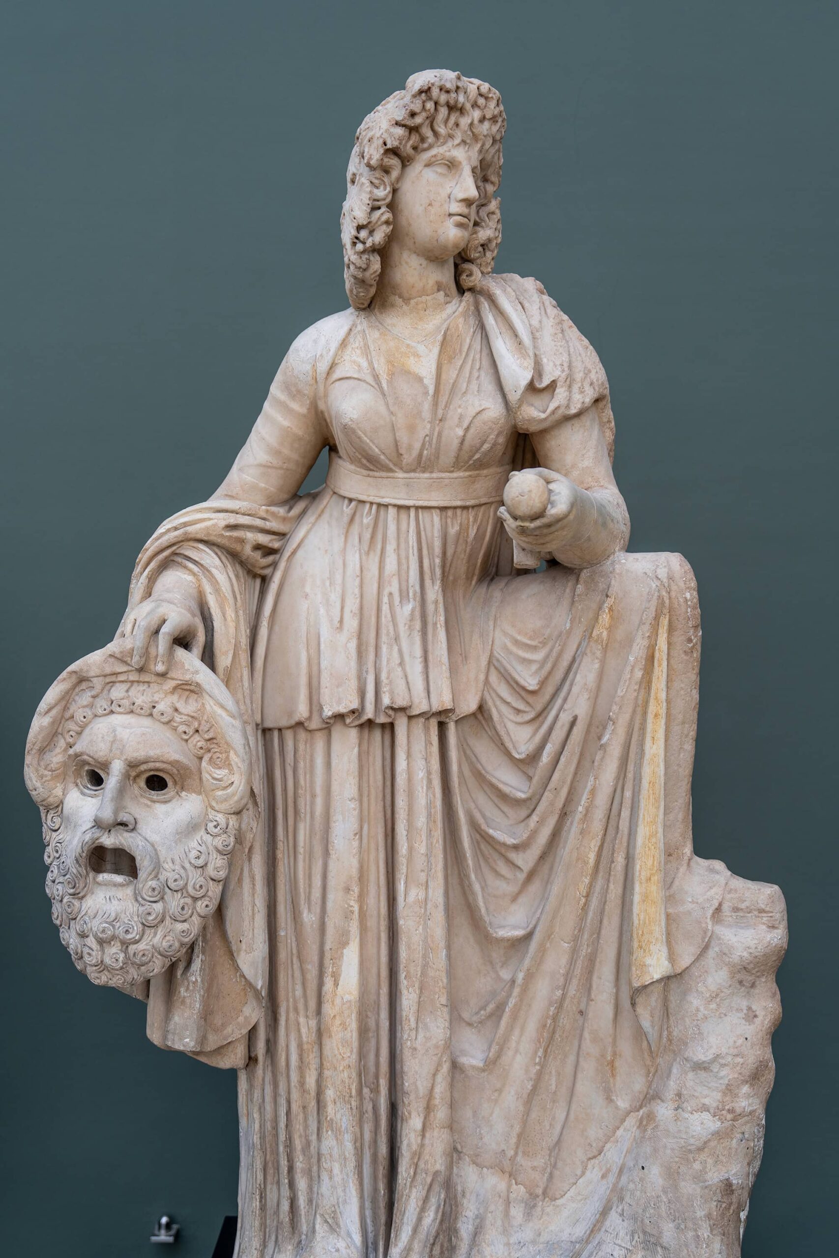 Ancient sculpture of Melpomene, the Muse of Tragedy, holding a theatrical mask at the Ny Carlsberg Glyptotek Museum