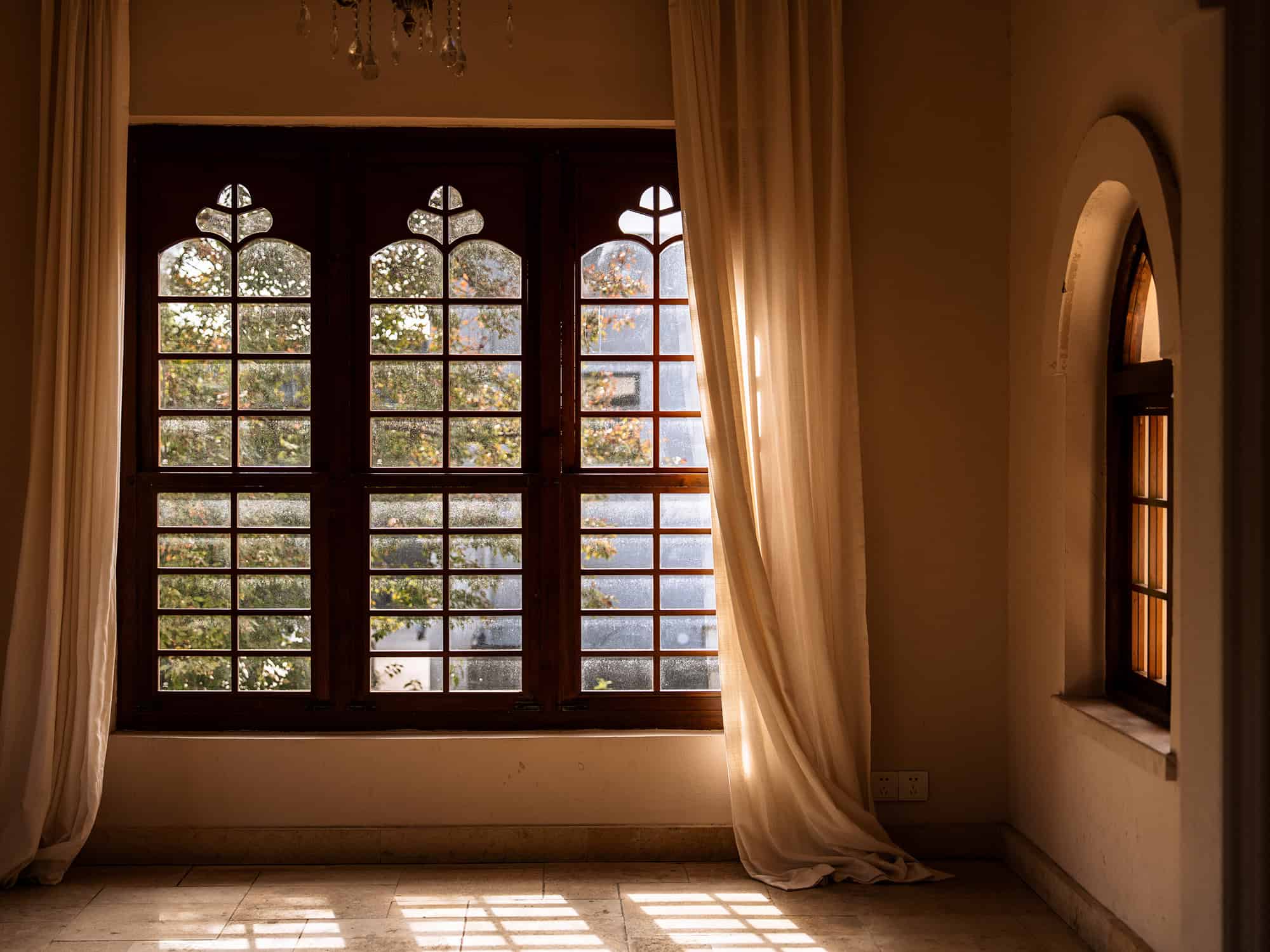 Elegant arched windows and flowing curtains at Yunxi Manor, capturing warm afternoon light