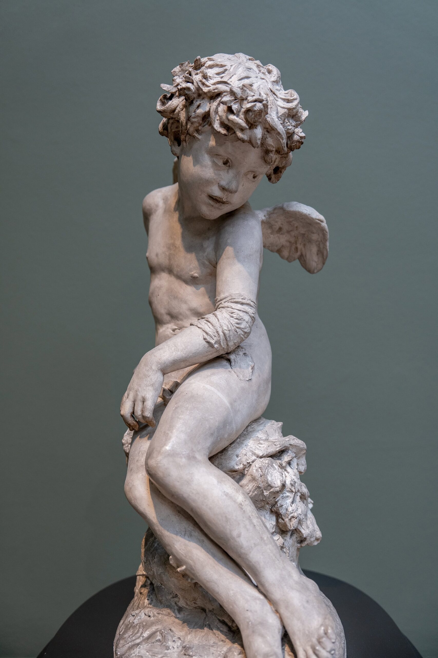 Wounded Cupid, an 1873 plaster sculpture by Jean‑Baptiste Carpeaux displayed at the Ny Carlsberg Glyptotek in Copenhagen, representing nineteenth‑century French Realist art