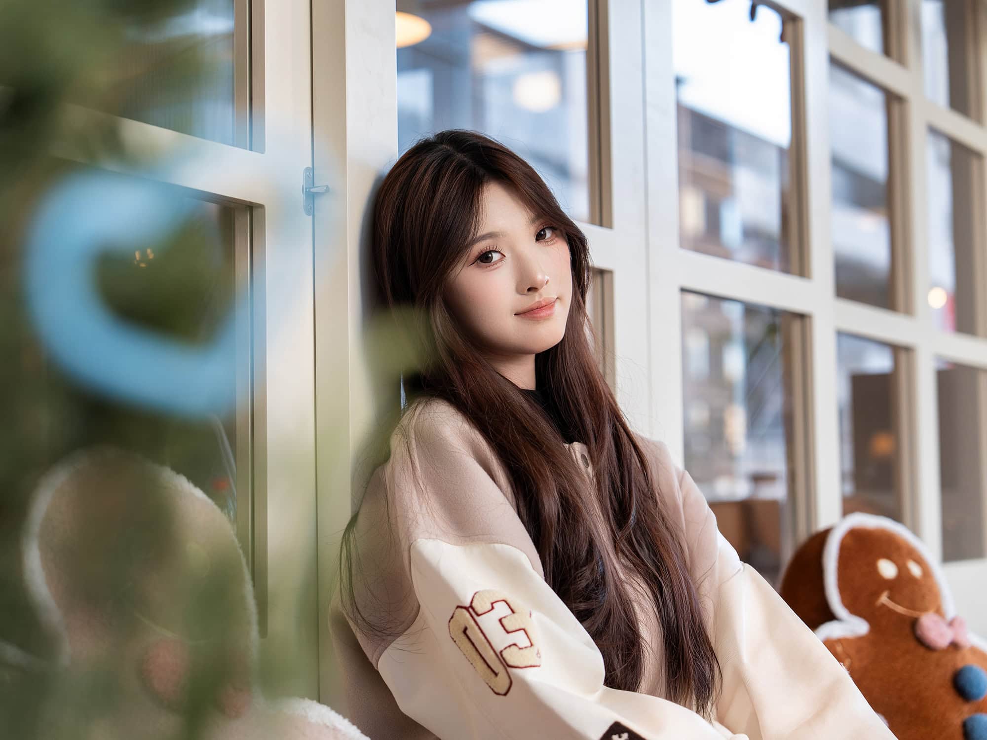 A young woman sitting on a chair by the window outside DONGUDONGU Korean Family Restaurant on the second floor of the Brighttower Art Community (BAC) in Zhuantang