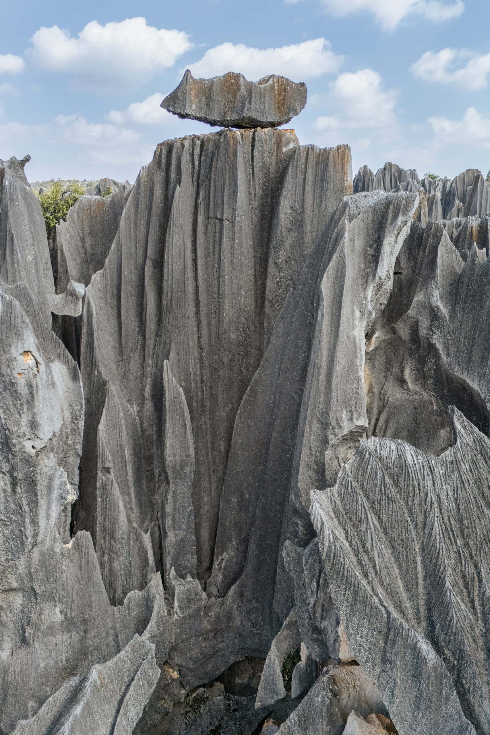Dramatic limestone fissures and a balanced rock formation in Shilin Stone Forest, Yunnan