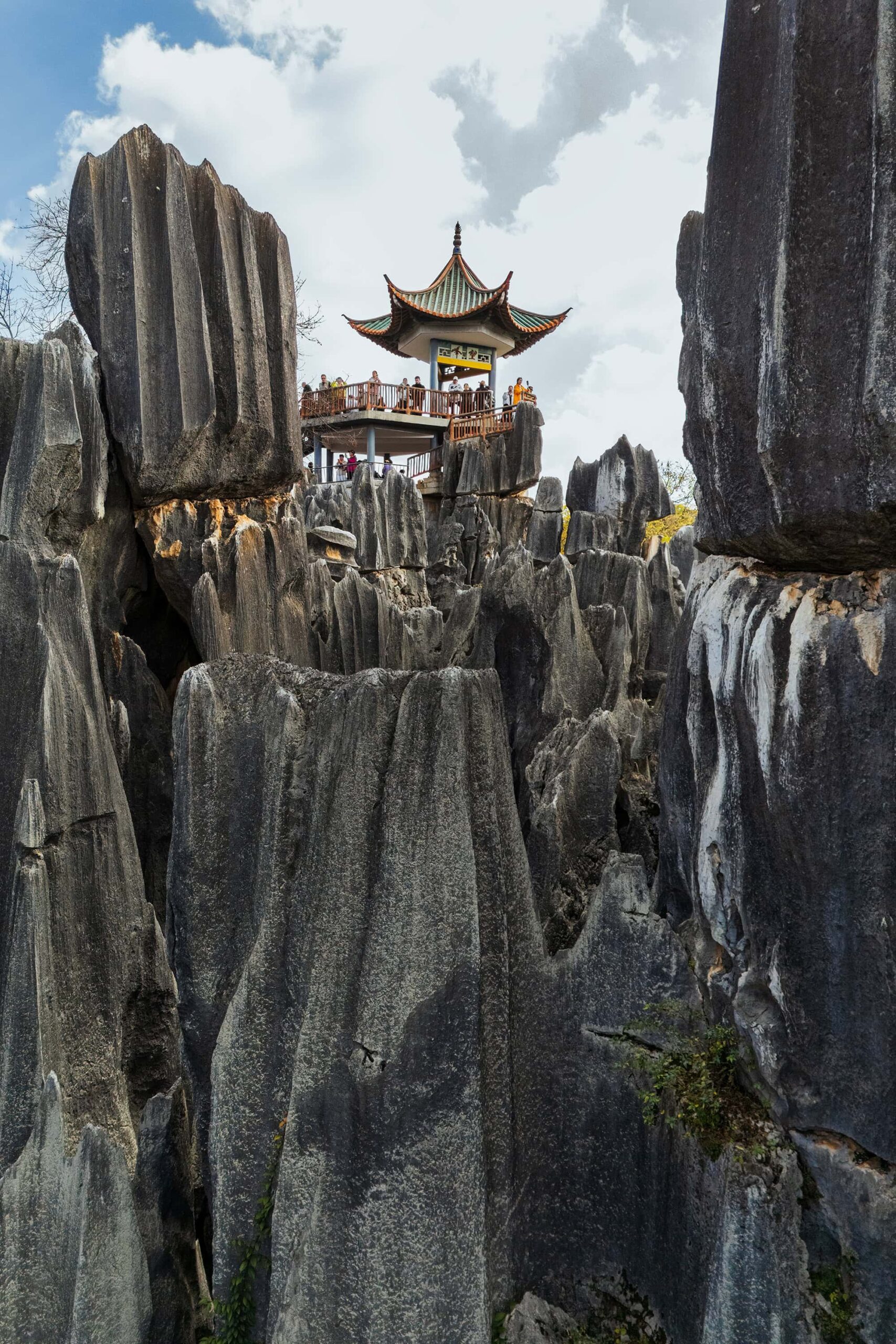 Wangfeng Pavilion framed by jagged limestone spires in Shilin Stone Forest, Kunming, Yunnan