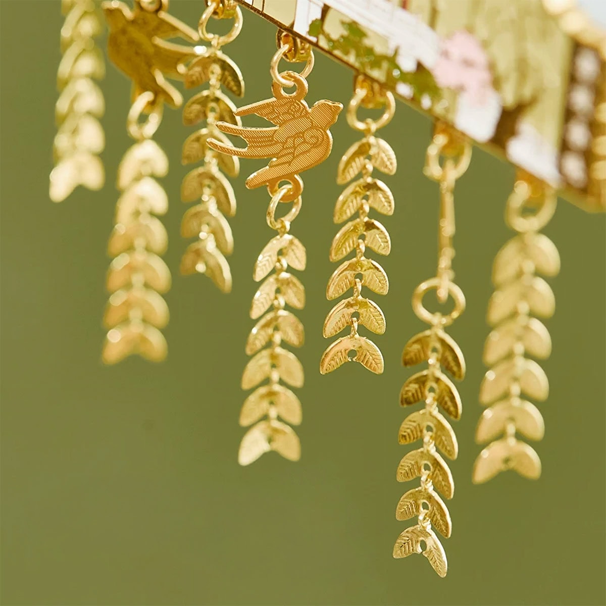 Close up of the Hangzhou West Lake fridge magnet charms, showing a dangling swallow pendant and gold willow leaf chains on the Su Causeway Dawn Sudi design