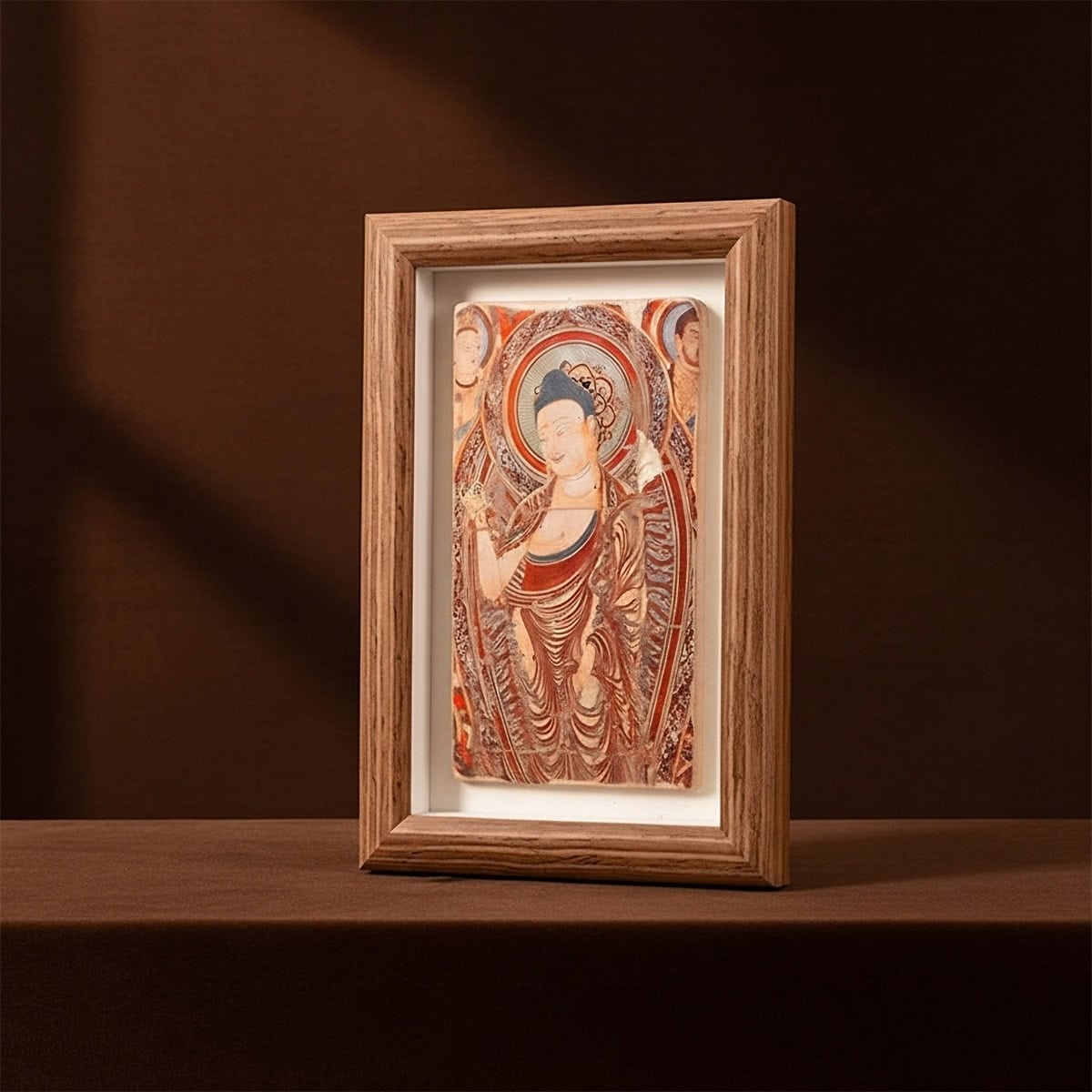 Framed handmade clay relief inspired by the Bezeklik Thousand Buddha Caves Turpan, shown as decorative wall art on a brown studio backdrop