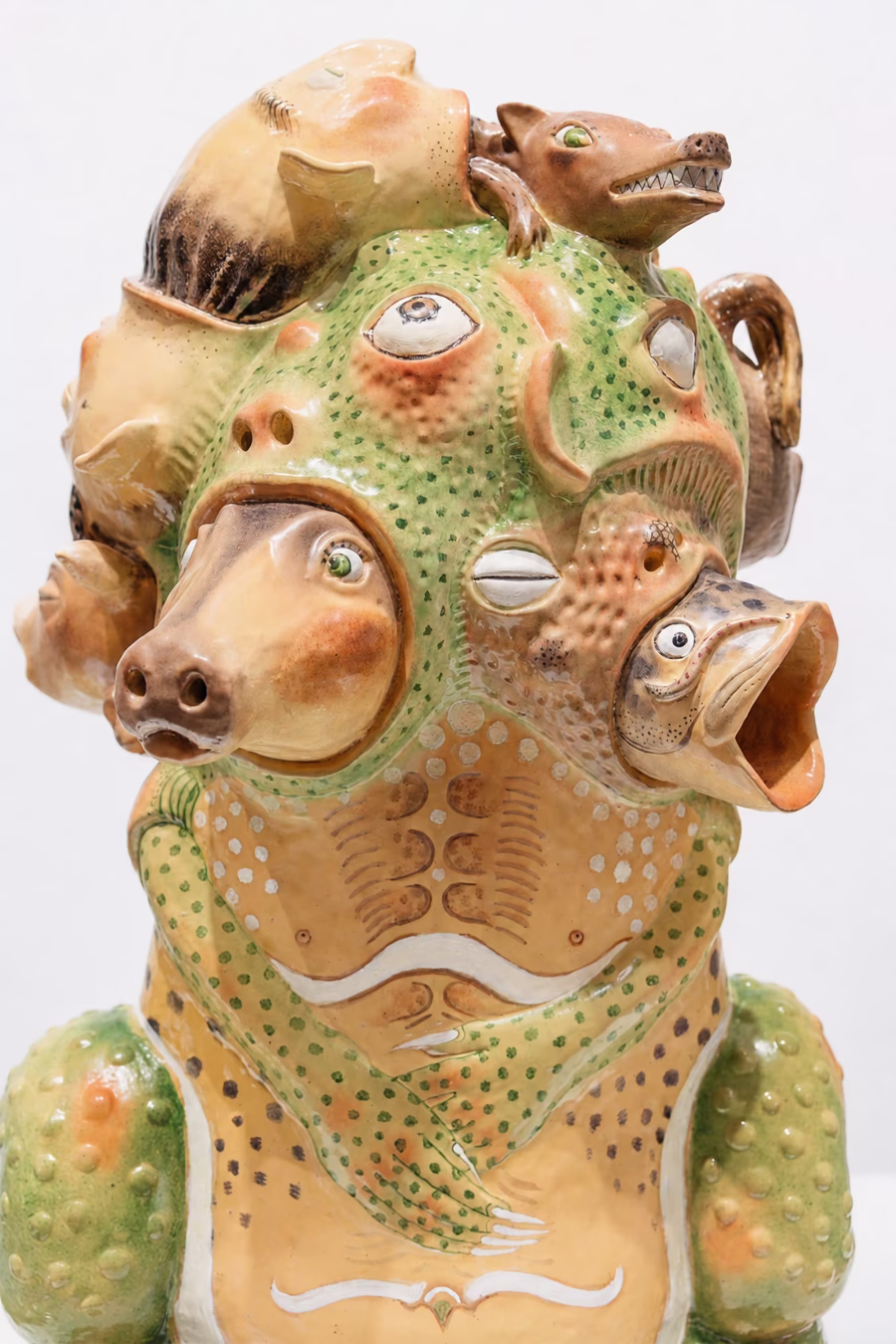 Chinese installation art ceramic sculpture by Wang Shuyi showing a textured human-animal hybrid form with animal faces and features emerging from the body surface, displayed at the graduate exhibition